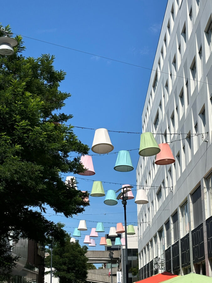 Über eine Straße gespannte bunte Lampenschirme.