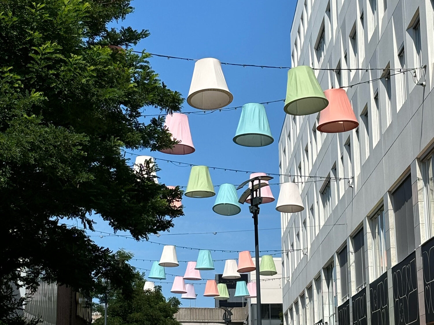 Über eine Straße gespannte bunte Lampenschirme.